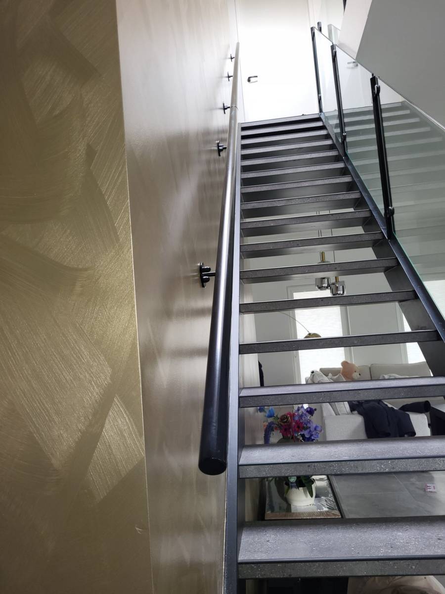 Gebogen trapleuning op maat langs een ronde trap
