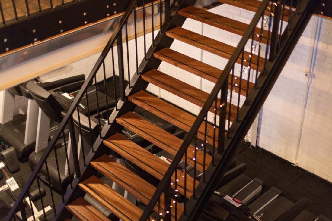 Stalen trap met balustrade en houten traptreden